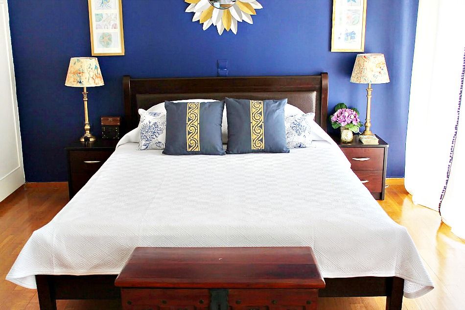 White duvet cover, blue pillows with gold stencil